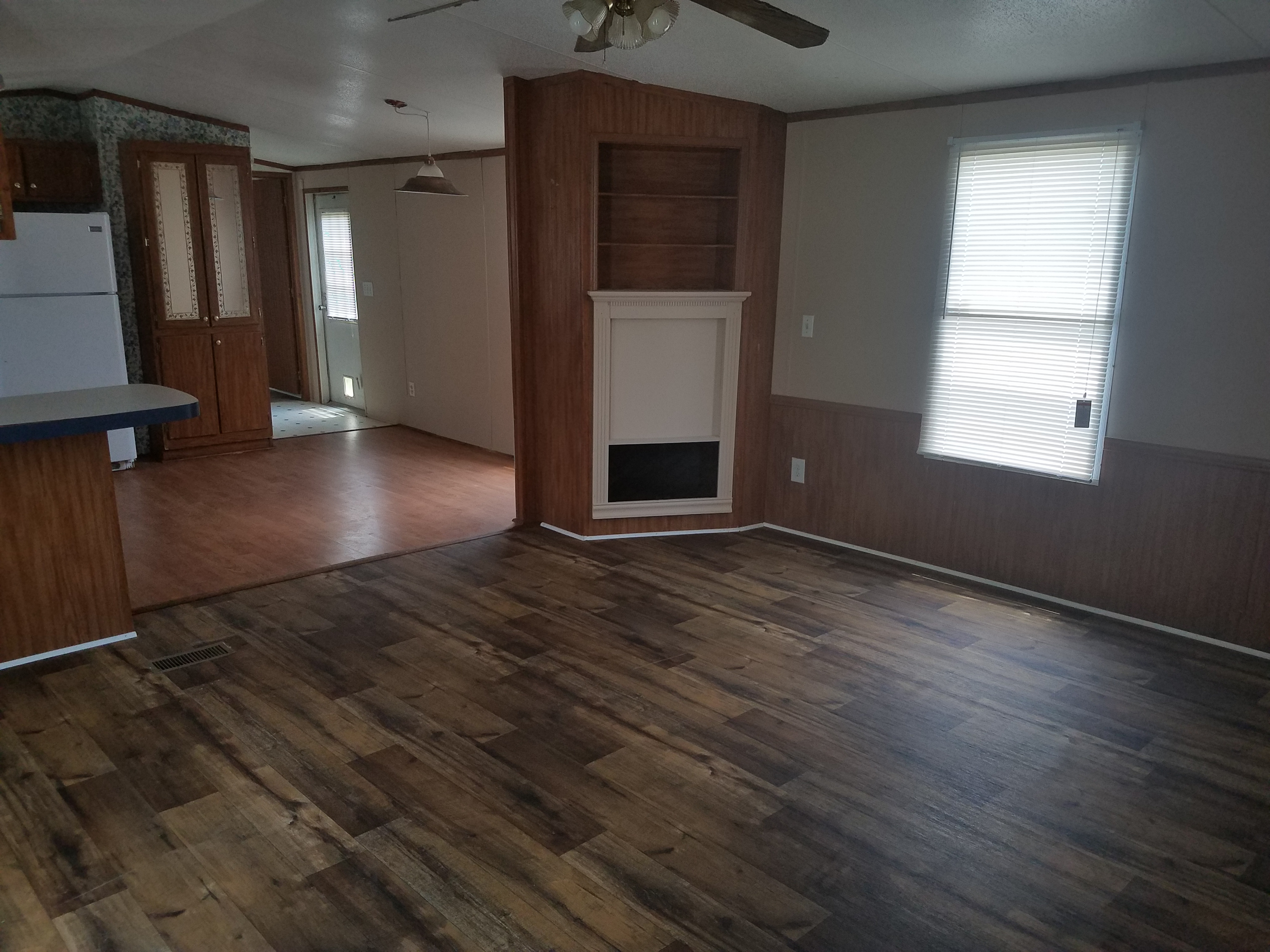 Lot 14: living room with wood-look flooring, a ceiling fan and a built-in fireplace