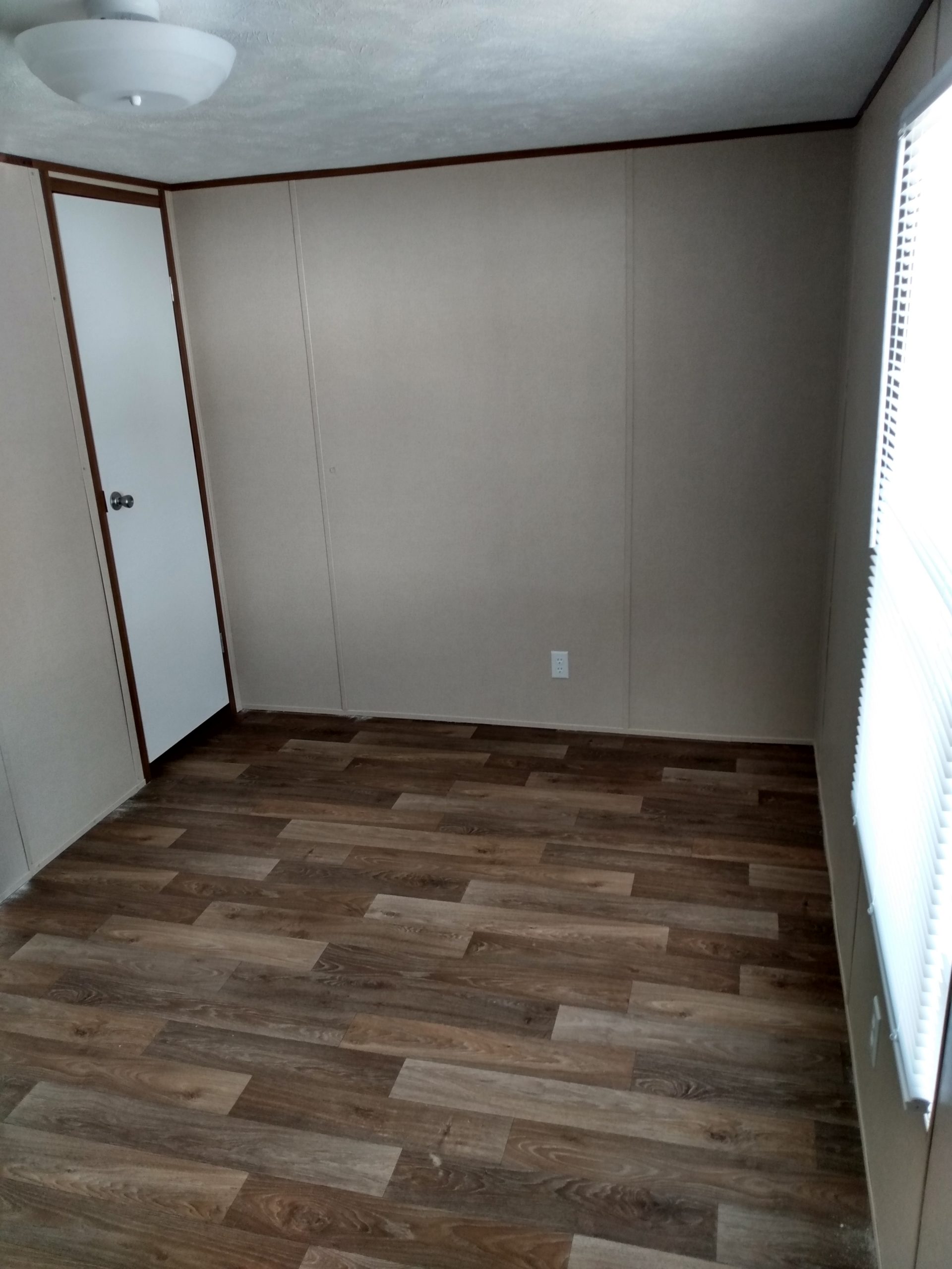 Room with a door, a window and wood-look flooring