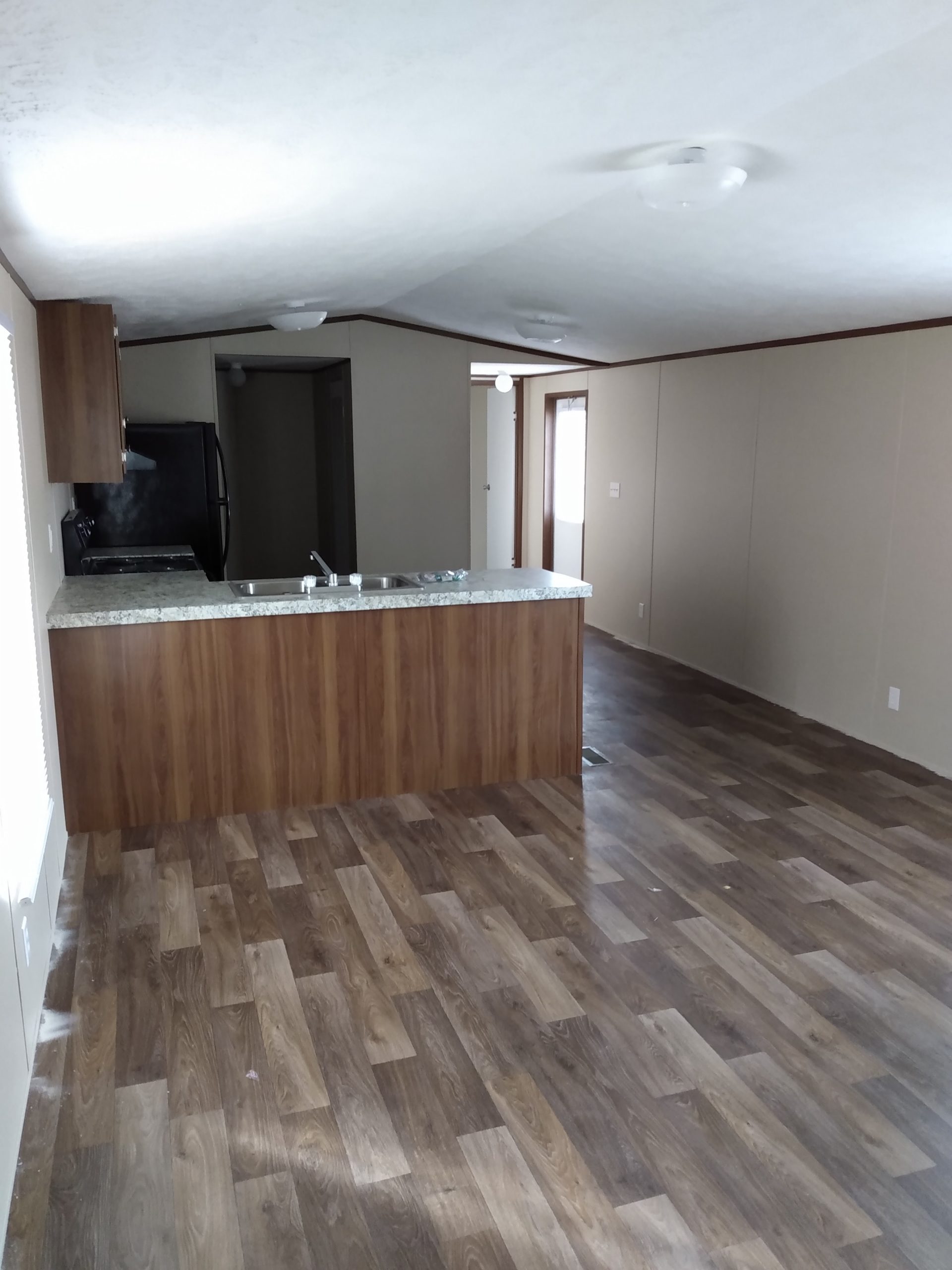 Kitchen with a counter island and open living area, seen from the living room